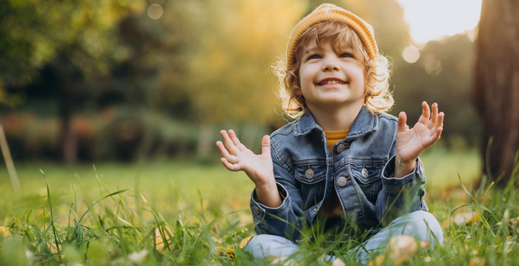 a child sitting in the grass after pediatric cognitive behavioral therapy